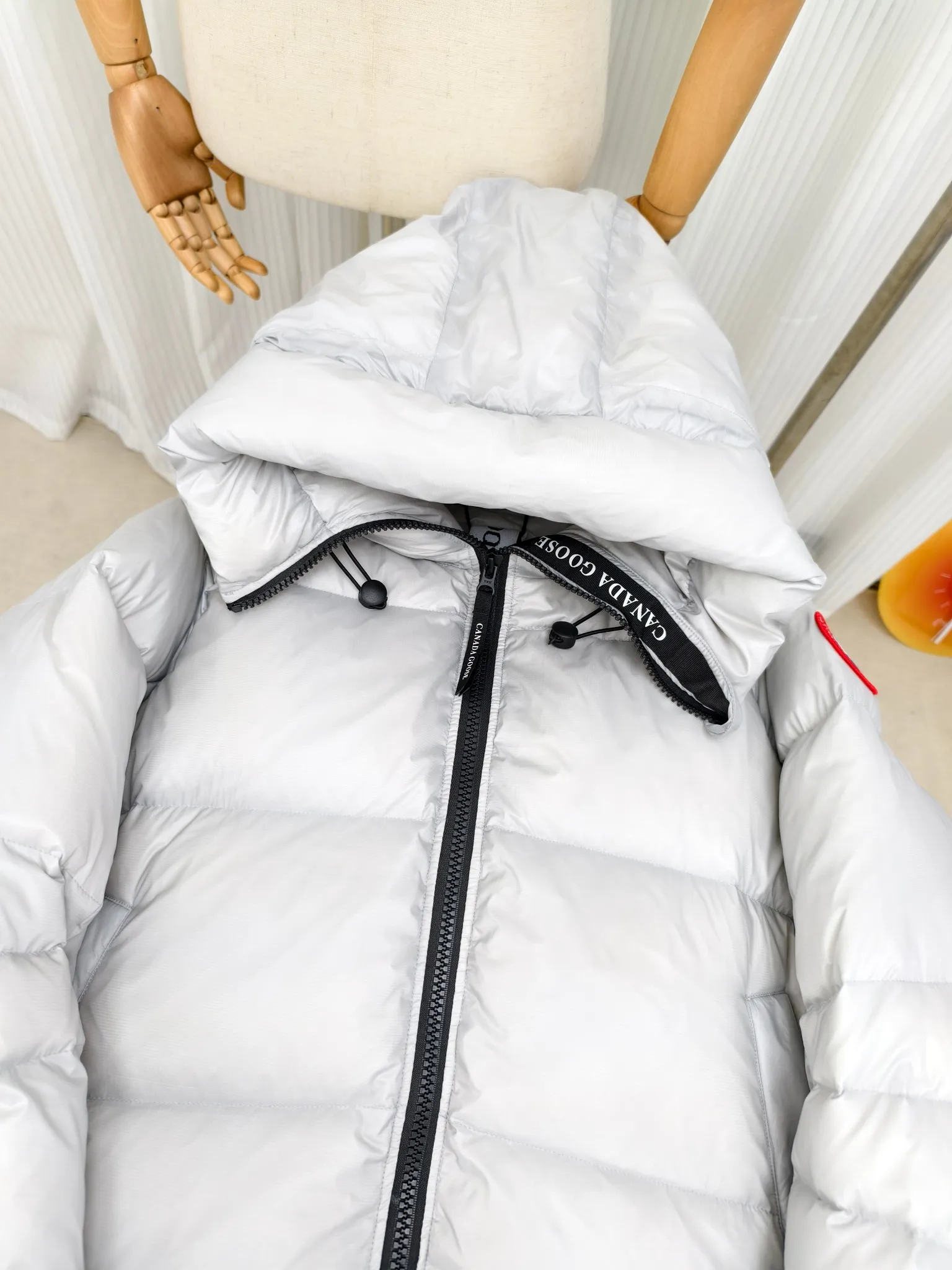 P940 ————2239L women's model (high version) Canada goose Cypress down jacket The new model of the Cypress series makes you stand out. This down jacket is an ideal winter piece. This style is filled with white duck down. Featuring a thin, channel-filled construction with lightweight fabrics and trim, it feels lightweight and adds warmth. The chin-protecting suede knit stand-up collar is soft and adds comfort. An adjustable down hood with cord closure adds warmth and protection against the elements. The back is designed with the iconic double-stripe black reflective decorative stripes to make you more visible in dim environments. The inner layer has removable elastic straps, making the jacket easy to carry on the shoulder and hands-free. Side zipper gusset dries and breathes when moving. Color: black with red label, silver birch Size: XS-2XL